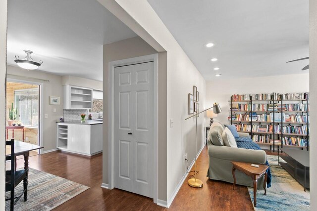 sitting room featuring recessed lighting, dark wood-type flooring, and baseboards