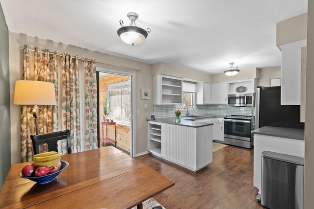 kitchen featuring tasteful backsplash, open shelves, appliances with stainless steel finishes, white cabinetry, and a sink