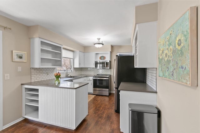 kitchen with open shelves, appliances with stainless steel finishes, a peninsula, white cabinets, and a sink