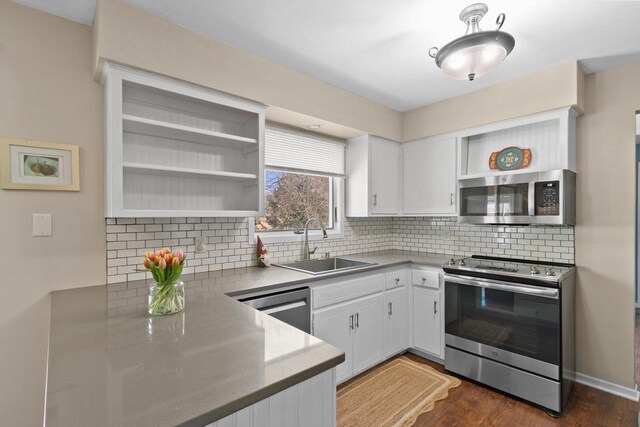 kitchen featuring open shelves, a sink, white cabinets, appliances with stainless steel finishes, and backsplash