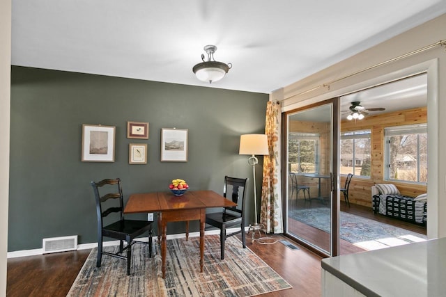 dining area featuring dark wood-style floors, visible vents, and baseboards