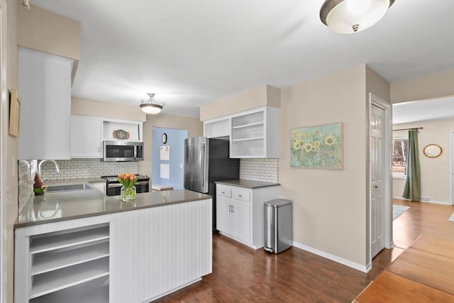 kitchen featuring open shelves, appliances with stainless steel finishes, dark wood-style floors, and a sink