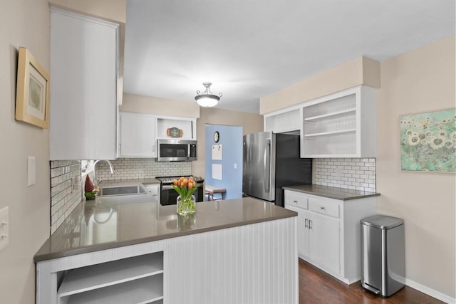 kitchen featuring open shelves, a peninsula, a sink, appliances with stainless steel finishes, and white cabinetry