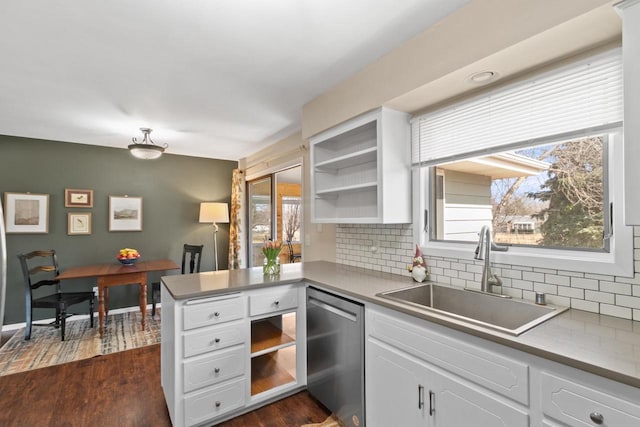 kitchen with dark wood-type flooring, a sink, open shelves, a peninsula, and dishwasher