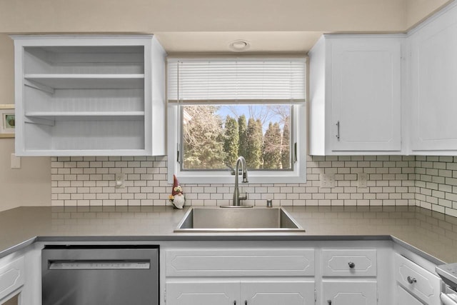 kitchen featuring dishwasher, decorative backsplash, white cabinetry, and a sink