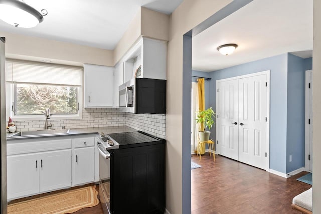 kitchen with white cabinetry, tasteful backsplash, appliances with stainless steel finishes, and a sink