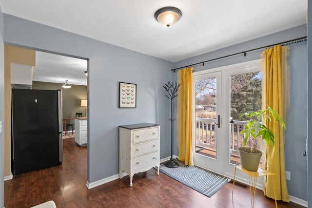 doorway to outside featuring wood finished floors, baseboards, and french doors