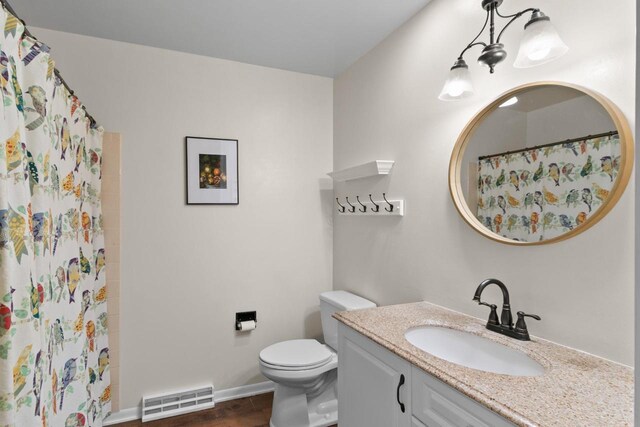 bathroom with visible vents, curtained shower, toilet, wood finished floors, and vanity