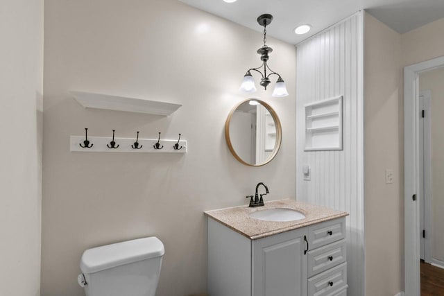 bathroom featuring vanity, toilet, and a chandelier