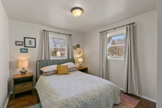 bedroom with dark wood-style floors and baseboards