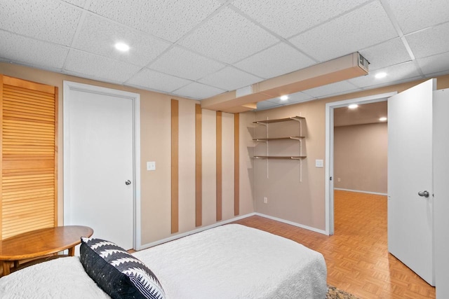 bedroom featuring a closet, recessed lighting, baseboards, and a drop ceiling