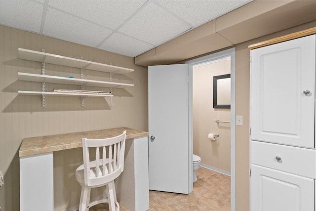 bathroom with toilet and a drop ceiling