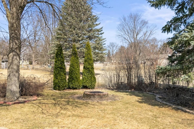 view of yard with a fire pit and fence