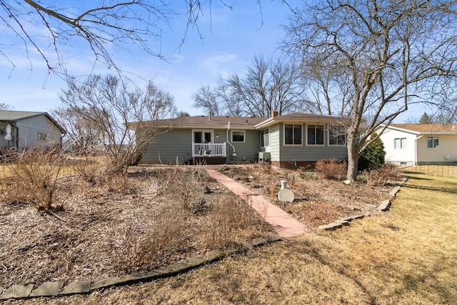 rear view of house featuring a porch and a chimney