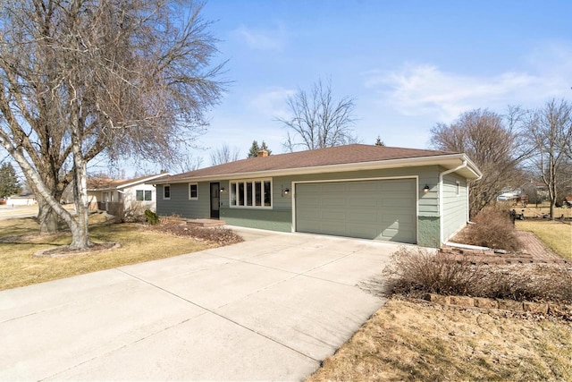 ranch-style home with a chimney, an attached garage, concrete driveway, and a front yard