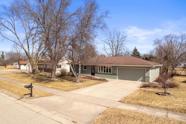 ranch-style house with a garage, concrete driveway, and a chimney