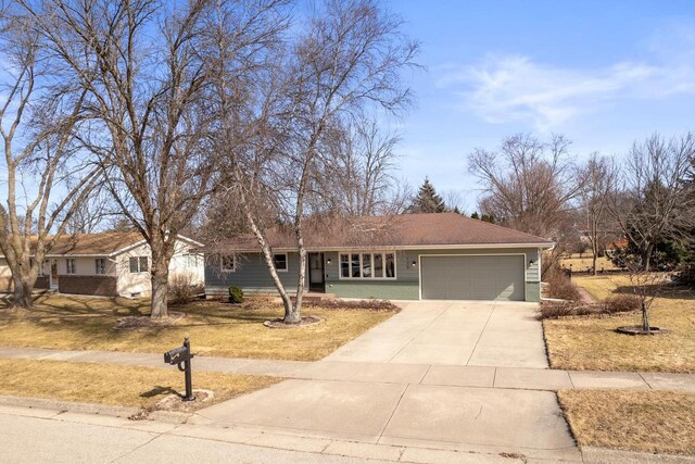 ranch-style house with concrete driveway and a garage