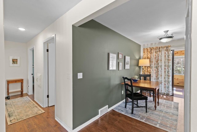 dining room featuring visible vents, baseboards, and wood finished floors