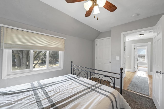 bedroom with multiple windows, baseboards, lofted ceiling, and a ceiling fan