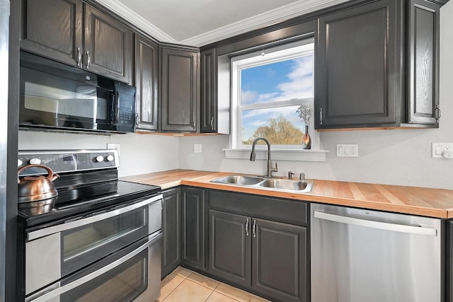 kitchen featuring light tile patterned floors, wooden counters, a sink, stainless steel appliances, and crown molding