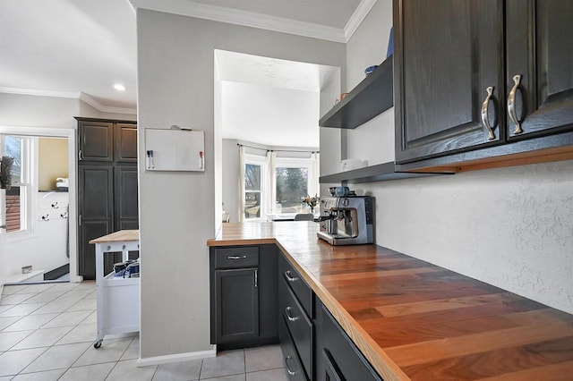 kitchen with light tile patterned floors, butcher block counters, and crown molding