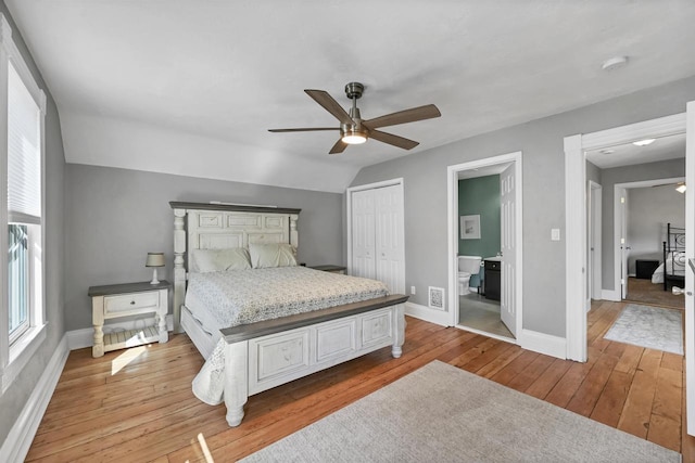 bedroom with lofted ceiling, light wood-style flooring, visible vents, and baseboards