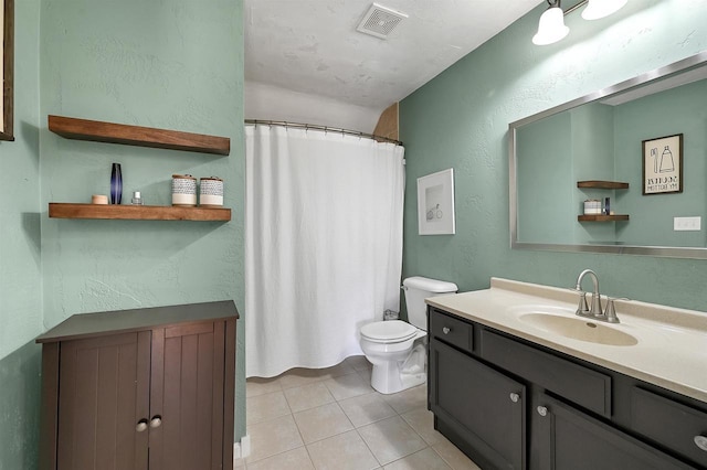 full bath with vanity, visible vents, tile patterned floors, toilet, and a textured wall