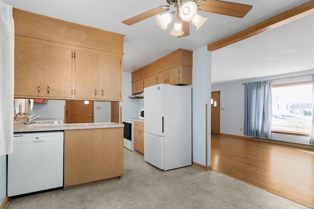 kitchen with white appliances, light floors, a sink, light countertops, and under cabinet range hood