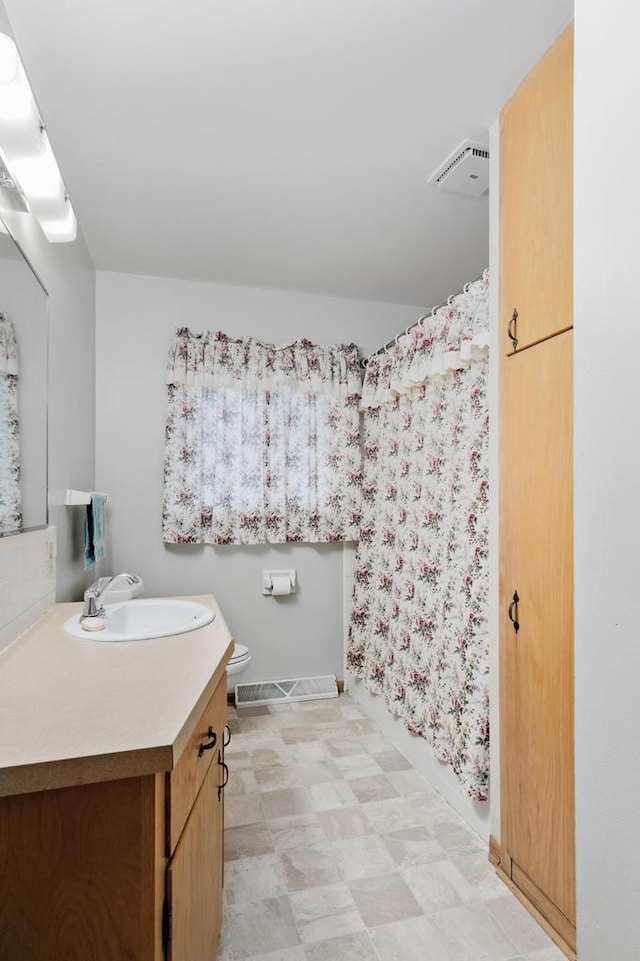 bathroom featuring visible vents, toilet, curtained shower, and vanity