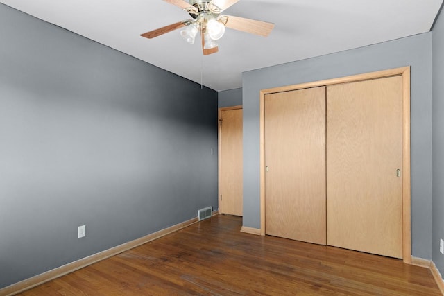 unfurnished bedroom featuring visible vents, baseboards, and wood finished floors