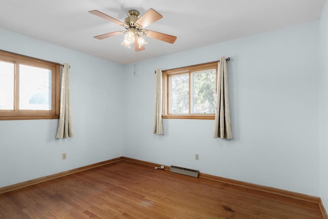 empty room featuring visible vents, a ceiling fan, light wood-type flooring, and baseboards