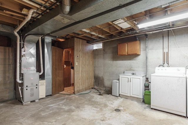 unfinished basement featuring heating unit, washing machine and dryer, and a sink