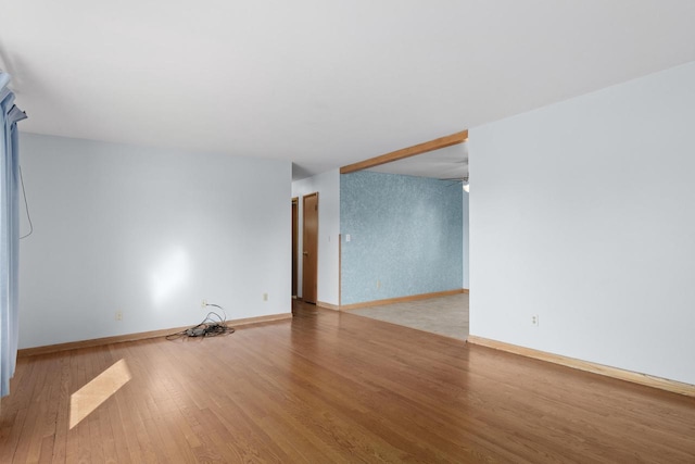 empty room featuring baseboards and wood finished floors