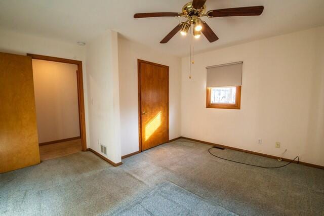 unfurnished bedroom with baseboards, carpet floors, visible vents, and a ceiling fan