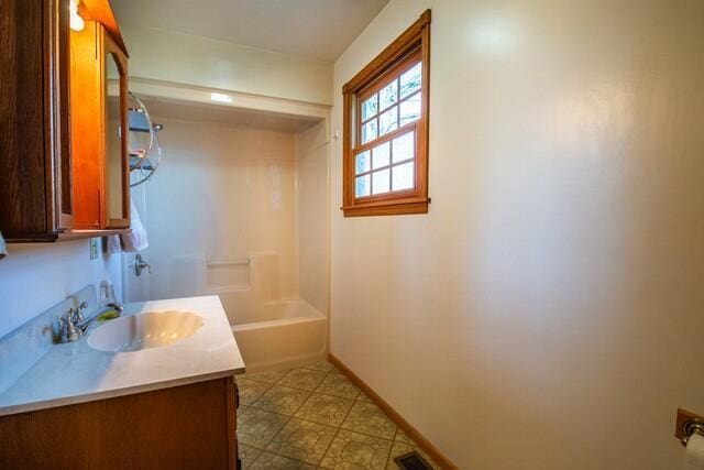 full bathroom featuring visible vents, baseboards, bathing tub / shower combination, and vanity