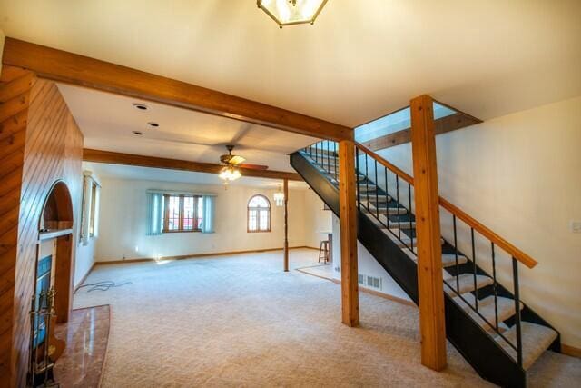 living room with visible vents, baseboards, beamed ceiling, stairs, and carpet floors