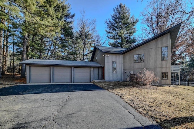 view of front of property featuring aphalt driveway and a garage