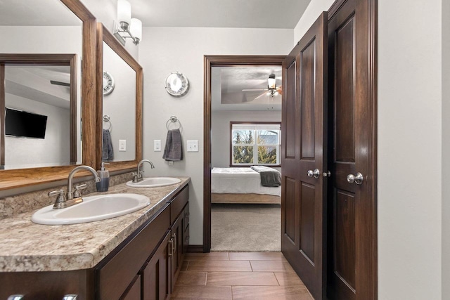 bathroom featuring double vanity, ensuite bath, a ceiling fan, and a sink