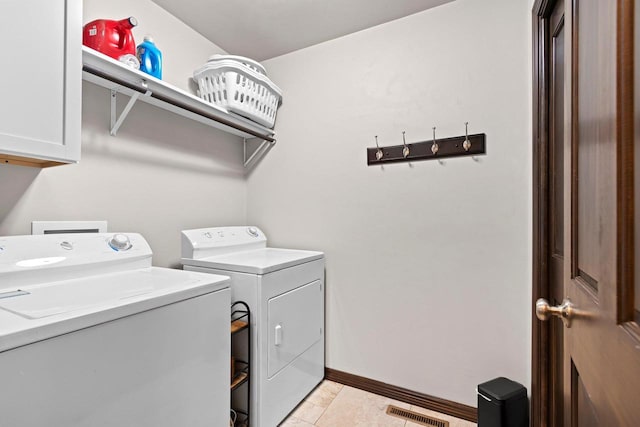 laundry room featuring visible vents, baseboards, light tile patterned floors, washer and dryer, and cabinet space