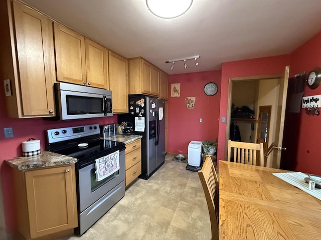 kitchen with butcher block counters, track lighting, and stainless steel appliances