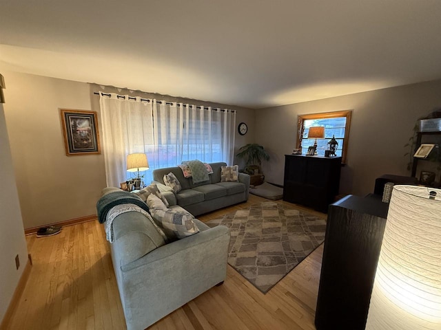 living room with baseboards and wood finished floors