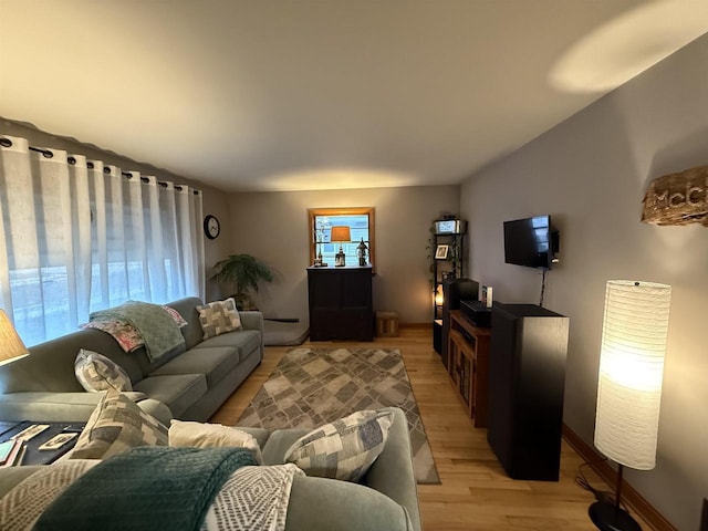 living area featuring baseboards and light wood-type flooring