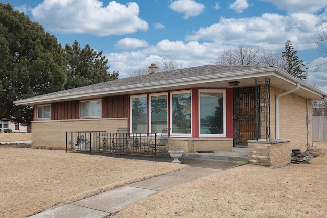 single story home with brick siding, roof with shingles, and a chimney