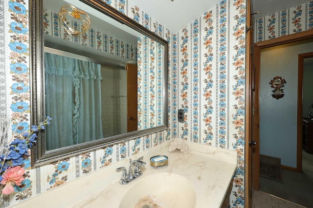 bathroom with a sink, tile patterned floors, and wallpapered walls