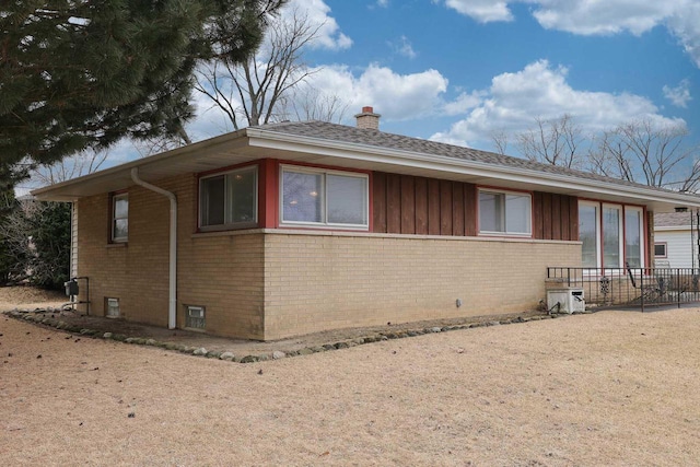 view of front of property featuring brick siding, board and batten siding, and a chimney