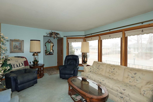 living area featuring baseboards and light colored carpet