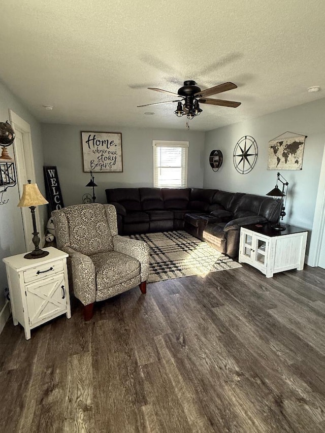 living room with dark wood-type flooring, a ceiling fan, and a textured ceiling