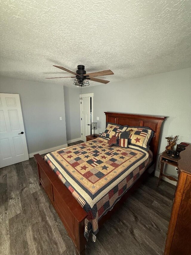 bedroom featuring dark wood finished floors, baseboards, a textured ceiling, and ceiling fan