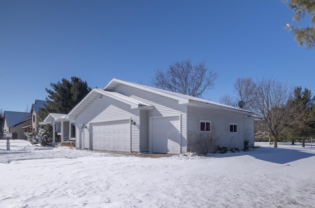 view of snowy exterior featuring a garage