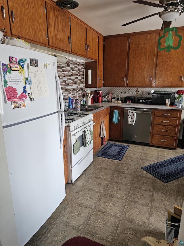 kitchen featuring tile patterned floors, a ceiling fan, a sink, white appliances, and brown cabinetry